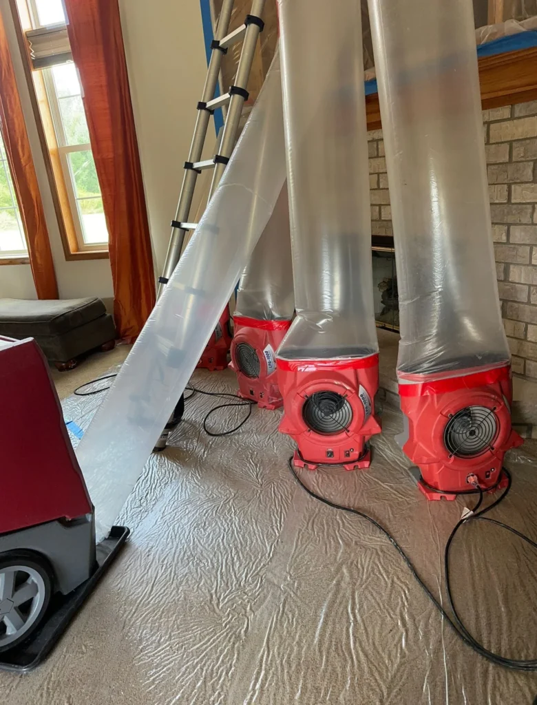 Plastic containment with red air scrubbers and ducting set up to clean the air during restoration