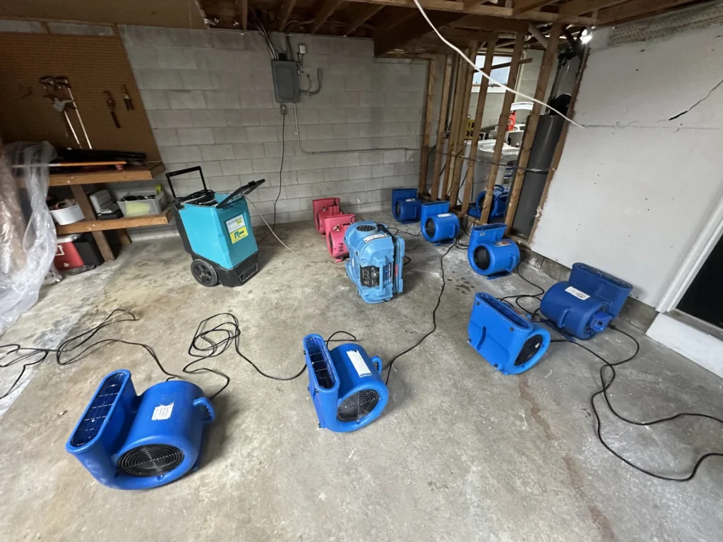 Rows of air movers drying a basement after flood water was extracted