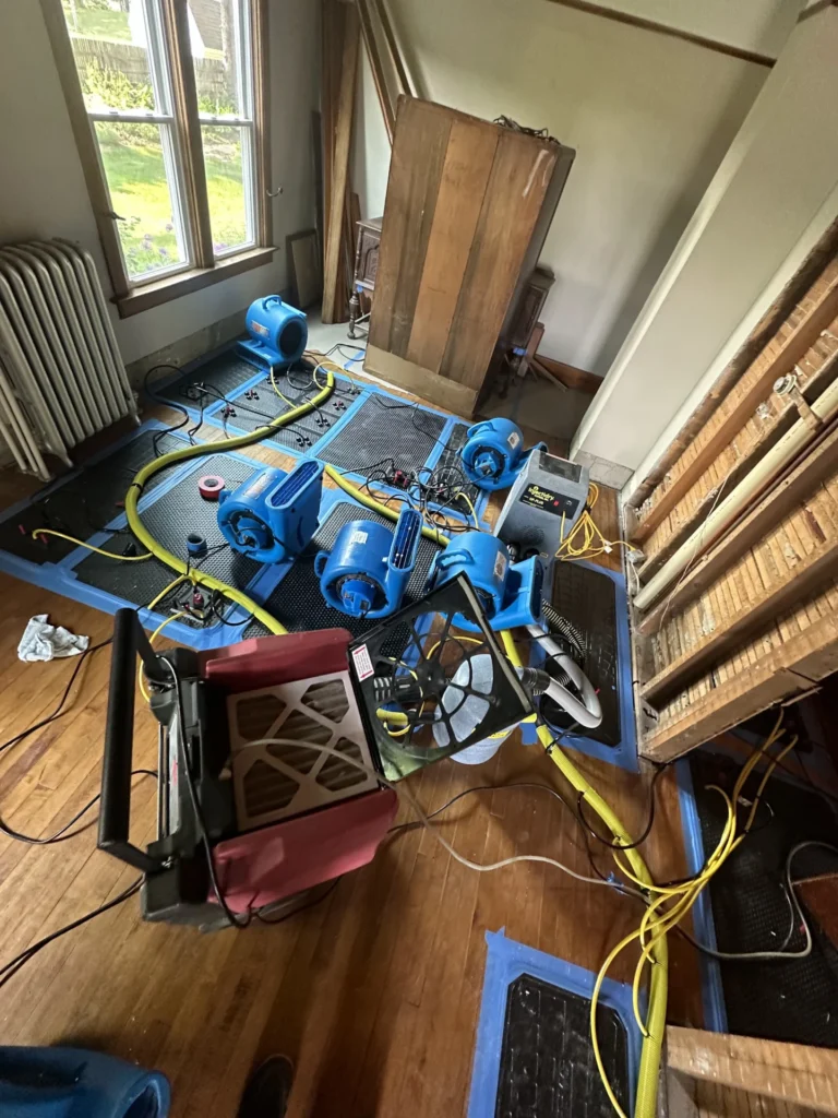 Drying equipment set up on a hardwood floor after a water leak