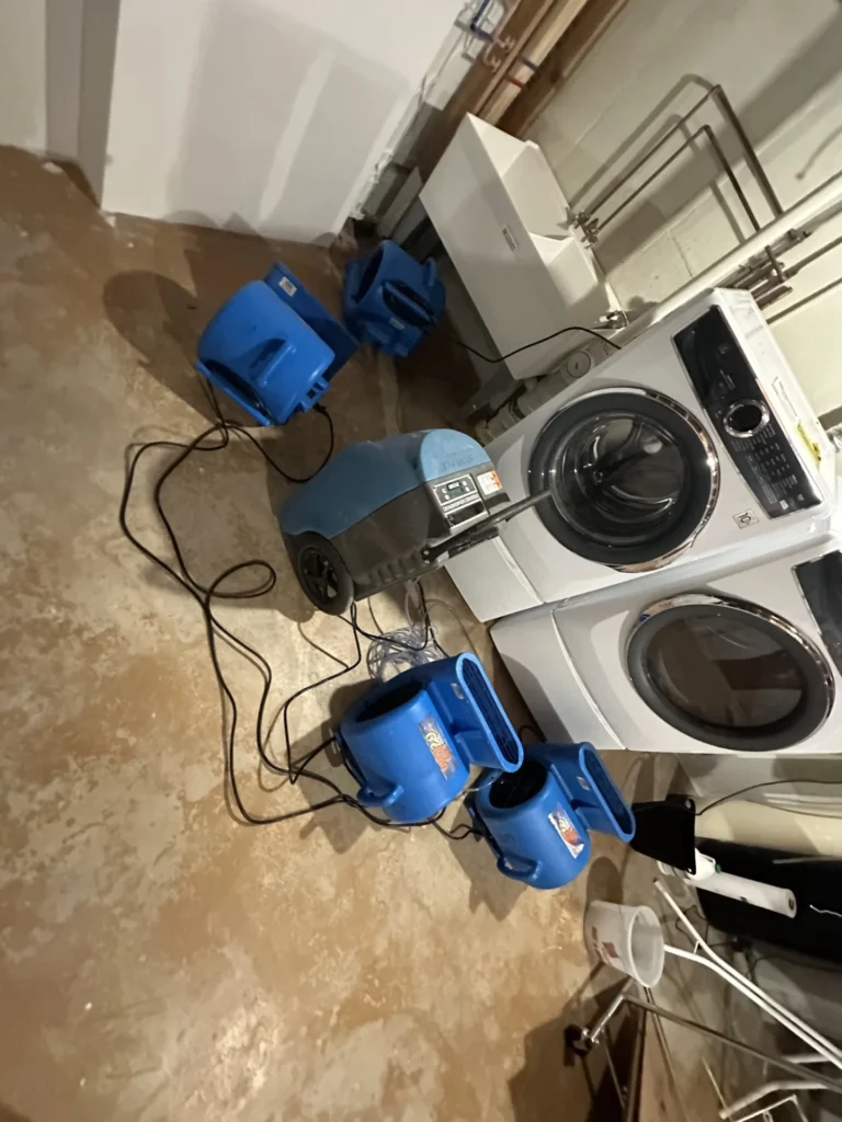 Air movers drying a laundry room floor after water damage