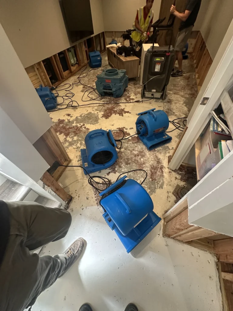 Air movers drying a subfloor after damaged flooring was removed